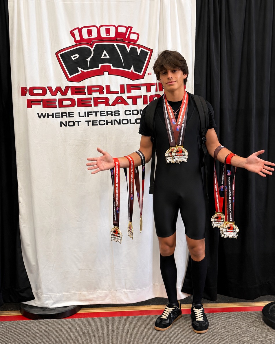 Lucas Weatherwax posing with his Texas state record medals in front of a 100% Raw Powerlifting Federation backdrop