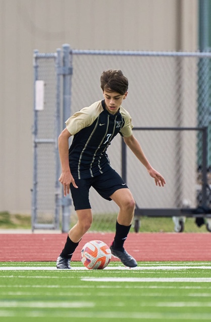 Lucas Weatherwax dribbling the ball during a JVB soccer match, freshman season